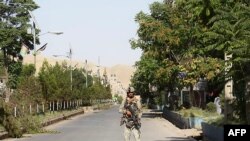 An Afghan security forces personnel stands guard along a road amid ongoing fighting with Taliban fighters in the western city of Qala-i- Naw, the capital of Badghis province, July 8, 2021. 