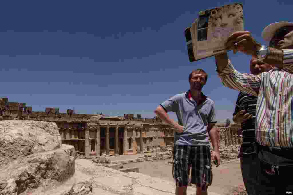 A tour guide shows Danish engineer Hans Brink (second from left) and a colleague around the Roman ruins. (John Owens for VOA News)
