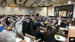 (FILE) Iraqi lawmakers attend a parliamentary session to vote on the federal budget at the parliament headquarters in Baghdad.