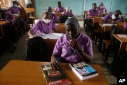 FILE - Students from Oregun Junior and Senior High School, wearing face mask to protect against coronavirus attend lectures inside a class room in Lagos, Nigeria, Jan. 18, 2021.