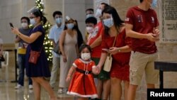 Sejumlah orang mengenakan masker wajah dan pelindung wajah untuk melindungi dari penularan Covid-19 saat misa Natal di Katedral Manila, Filipina, Jumat, 25 Desember 2020. (Foto: Lisa Marie David/ Reuters)