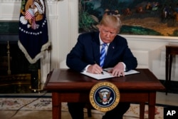 FILE - President Donald Trump signs a Presidential Memorandum on the Iran nuclear deal from the Diplomatic Reception Room of the White House, May 8, 2018.
