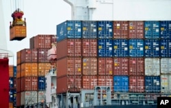 FILE - A container is loaded onto a cargo ship at the Tianjin port in China.