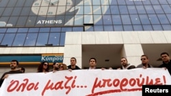 Employees of the Bank of Cyprus take part in a rally, in solidarity with crisis-hit Cypriots, outside the headquarters of the bank in Athens, Greece, Mar. 20, 2013. 