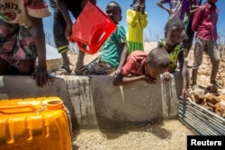FILE - Children drink water delivered by a truck in the drought stricken Baligubadle village near Hargeisa, the capital city of Somaliland, in this handout picture provided by The International Federation of Red Cross and Red Crescent Societies on March 15, 2017.