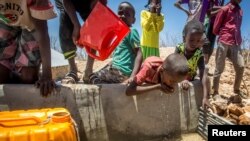 Children drink water delivered by a truck in the drought stricken Baligubadle village near Hargeisa, the capital city of Somaliland, in this handout picture provided by The International Federation of Red Cross and Red Crescent Societies on March 15, 2017