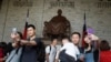 中国游客在台北中正纪念堂蒋介石铜像前摆姿势拍照。(2019年4月4日)
