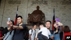 中國遊客在台北中正紀念堂蔣介石銅像前擺姿勢拍照。(2019年4月4日)