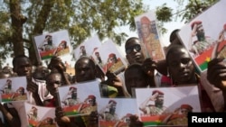 Des Burkinabès tiennent des photos de l'ancien président Thomas Sankara et du premier ministre Isaac Zida à Ouagadougou, le 2 décembre 2014.