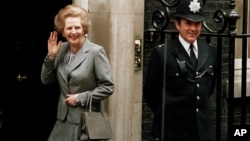 FILE - In this May 11, 1987 file photo, Britain's Prime Minister Margaret Thatcher waves to members of the media on returning to No. 10 Downing Street from Buckingham Palace after a visit with Queen Elizabeth II. 