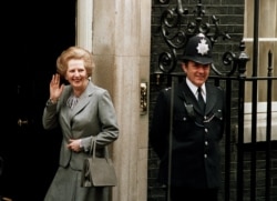 FILE - In this May 11, 1987 file photo, Britain's Prime Minister Margaret Thatcher waves to members of the media on returning to No. 10 Downing Street from Buckingham Palace after a visit with Queen Elizabeth II.