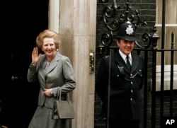 FILE - Britain's Prime Minister Margaret Thatcher waves to members of the media on returning to No. 10 Downing Street from Buckingham Palace after a visit with Queen Elizabeth II, May 11, 1987.
