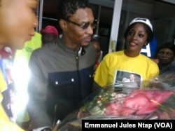 De retour au Cameroun, Rigobert Song reçoit un bouquet de fleurs à sa descente d'avion à l'aéroport international de Yaoundé Nsimalen, 1er avril 2017. (VOA/Emmanuel Jules Ntap)