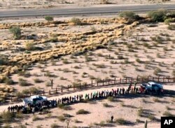 FILE - This aerial image released by the U.S. Customs and Border Protection shows migrants apprehended after illegally crossing along the U.S.-Mexico border near Lukeville, Ariz., Feb. 7, 2019.