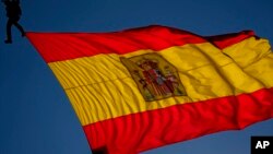 FILE - A Spanish flag flies in Madrid, Spain, Oct. 12, 2021. Iranian handball player Shaghayegh Bapiri defected to Spain in December 2021.