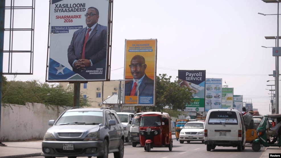 Motorists drive along a street with the campaign billboards of Somalia's Presidential candidates in Somalia's capital Mogadishu, Feb. 6, 2017.