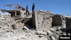 FILE - Men inspect a damaged house in Busra al-Harir, near Deraa, Syria, March 13, 2018. Russian jets struck the opposition-held town on June 24, 2018, opposition sources said.