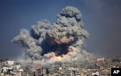 FILE - In this July 29, 2014 photo, smoke and fire from an Israeli air strike rise over Gaza City.