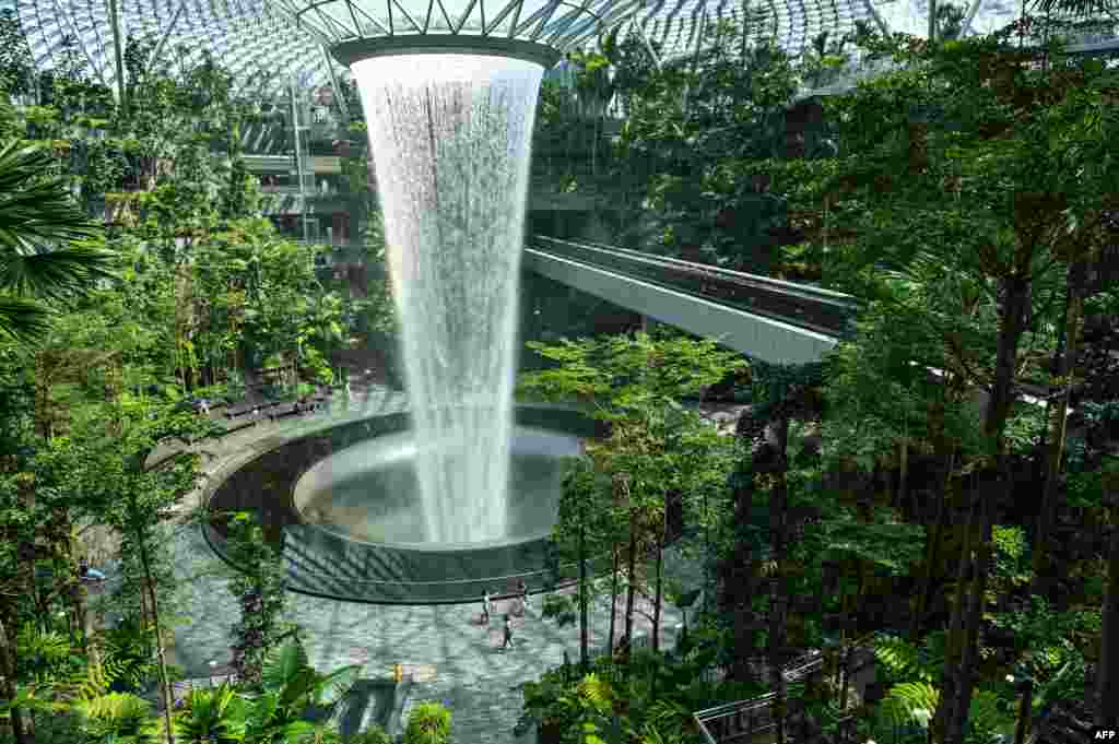 People walk around the rain vortex at Jewel Changi Airport in Singapore.