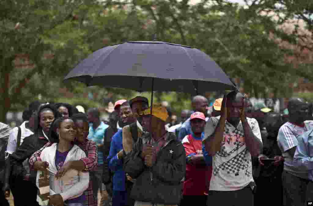 Workers line up outside the FNB stadium where the memorial service for South Africa President Nelson Mandela will take place on Tuesday, Johannesburg, Dec. 9, 2013. 