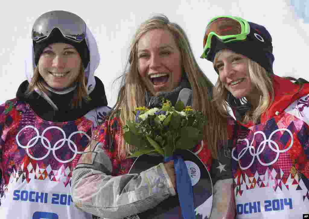 Jamie Anderson of the United States, center, celebrates with silver medalist Enni Rukajarvi of Finland, left, and bronze medalist Jenny Jones of Britain, after Anderson won gold in the women&#39;s snowboard slopestyle, Krasnaya Polyana, Russia, Feb. 9, 2014.