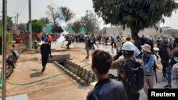 People flee to safety during an anti-coup protest in Loikaw, Myanmar March 9, 2021 in this still image obtained by Reuters ATTENTION EDITORS - THIS IMAGE HAS BEEN SUPPLIED BY A THIRD PARTY. NO RESALES. NO ARCHIVES.