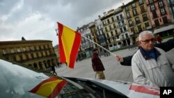 A woman holds up a Spanish flag during an election rally to officially open the General Election campaign in Pamplona northern Spain, Thursday, April 11, 2019. 