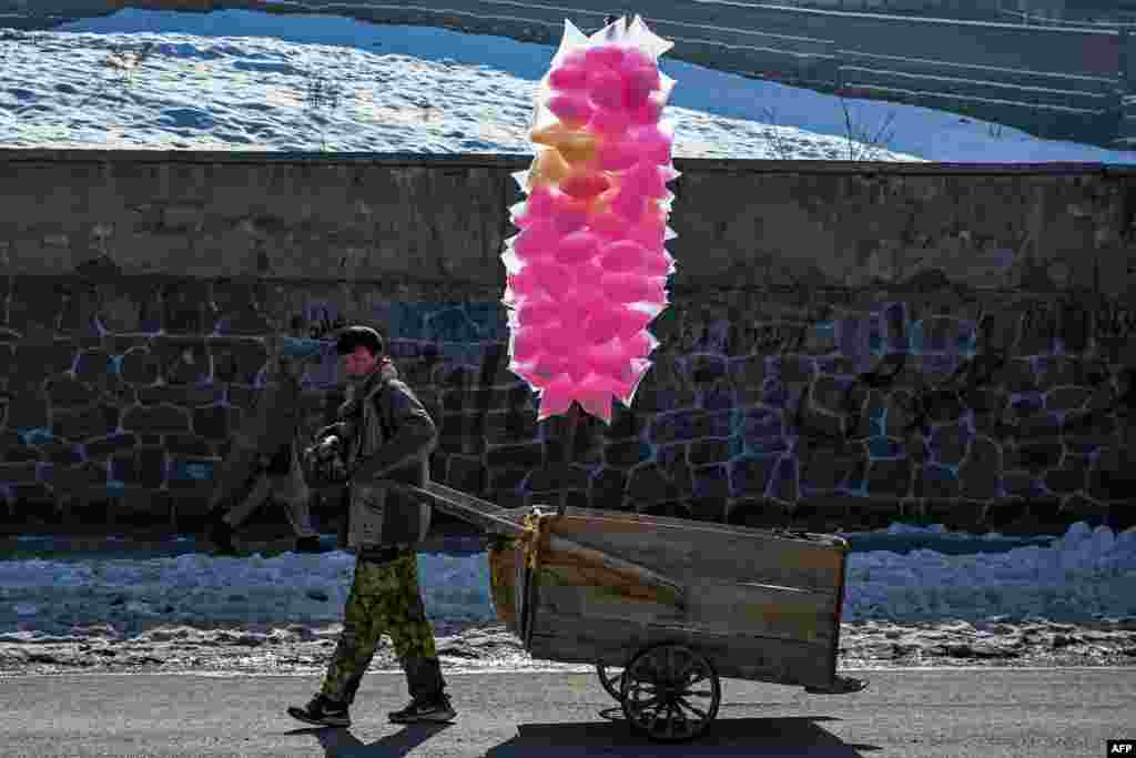 An Afghan boy pulls a cart containing cotton candy sweets along a street in Kabul.