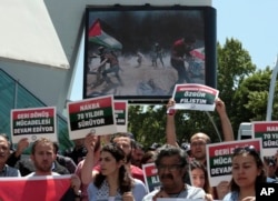 Turkish protesters hold placards that read " Free Palestine" and " Struggle to return back home continue for 70 years " as they stage a protest near the U.S. embassy in Ankara, Turkey, May 15, 2018.