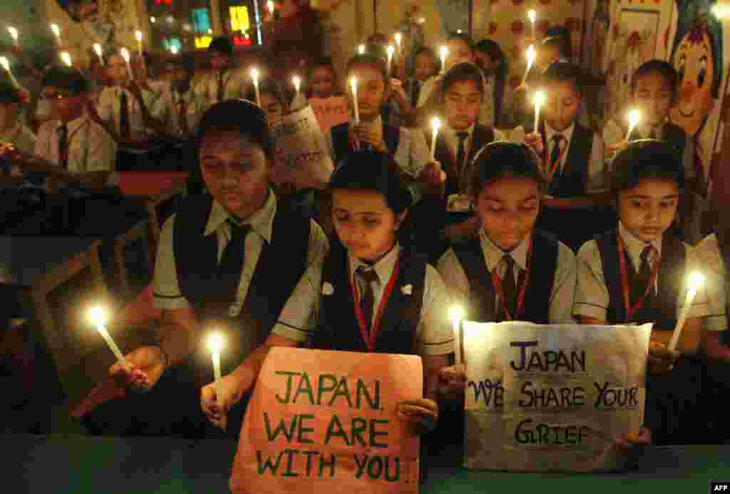 Студенты одного из учебных заведений города Ахмадабад на западе Индии с зажженными свечами оплакивают жертв землетрясения в Японии