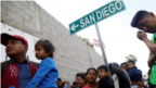 Di dân từ Trung Mỹ xếp hàng nhận quà sáng tại một trại tị nạn ở Tijuana, Mexico.