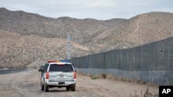 A U.S. Border Patrol agent drives near the U.S.-Mexico border fence in Sunland Park, New Mexico, Jan. 4, 2016.