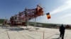 FILE - A worker walks in front of the drilling tower at Chevron's site during a media day in Pungesti.
