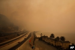 Traffic moves along the 101 Freeway as smoke from a wildfire fills the air in Ventura, California, Dec. 7, 2017.