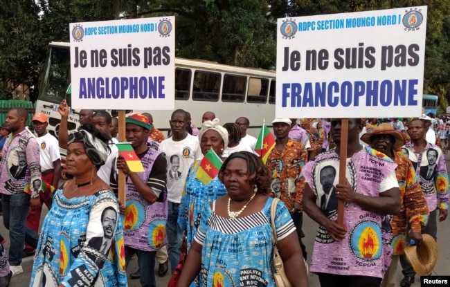 FILE - Demonstrators carry banners as they take part in a march voicing their opposition to independence or more autonomy for the anglophone regions, in Douala, Cameroon, Oct. 1, 2017.