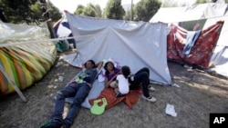 Una familia de migrantes venezolanos descansa fuera de un campamento improvisado en Quito, Ecuador. 