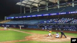 This Friday, April 24, 2020, photo, shows a baseball game between Chinatrust Brothers and Fubon Guardians with no audience at Xinzhuang Baseball Stadium in New Taipei City, Taiwan. (AP Photo/Chiang Ying-ying)