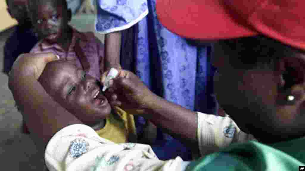 A four year-old child receives drops of polio vaccine at a nursery school.