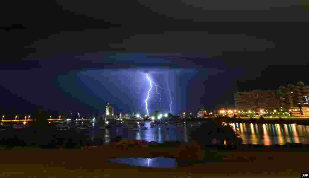 Lightning strikes behind the Port of Buceo during a thunderstorm early on Sunday morning in Montevideo, Uruguay.