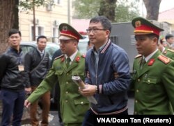 PetroVietnam's former chairman Trinh Xuan Thanh is escorted by police to the court in Hanoi, Vietnam, Jan. 8, 2018.