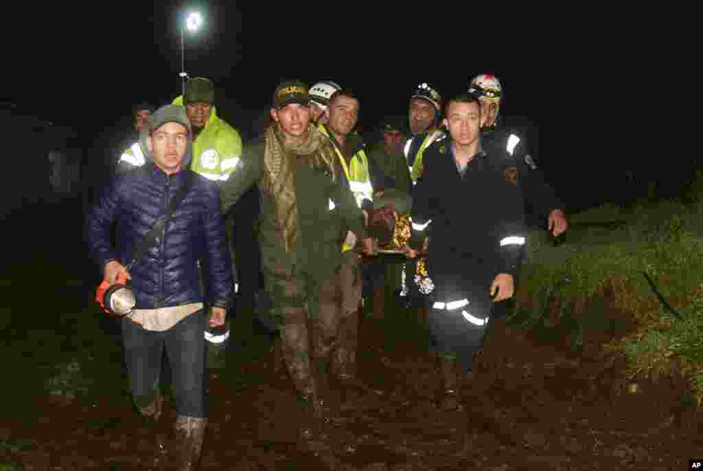 Equipas de resgate transportam o corpo de um sobrevivente do avião que caiu em La Union, uma área montanhosa nos arredores de Medellín, Colômbia.