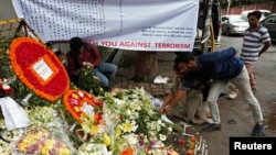 People place flowers at a makeshift memorial near the site, to pay tribute to the victims of the attack on the Holey Artisan Bakery and the O'Kitchen Restaurant, in Dhaka, Bangladesh, July 5, 2016. REUTERS/Adnan Abidi 