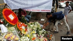 Mọi người đặt hoa tưởng niệm nạn nhân của hai cuộc tấn công vào nhà hàng Holey Artisan Bakery và O'KitchenRestaurant tại Dhaka, Bangladesh,ngày 5 tháng 7 năm 2016. REUTERS/Adnan Abidi 