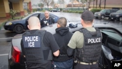 This photo released by U.S. Immigration and Customs Enforcement shows foreign nationals being arrested during a targeted enforcement operation aimed at immigration fugitives, re-entrants and at-large criminal aliens in Los Angeles, Feb. 7, 2017.