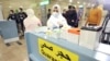 Des agents de la santé se préparent à prendre la température corporelle des voyageurs qui arrivent à l'aéroport international du Caire le 1er février 2020, (AFP)