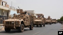 Yemeni fighters against Shiite rebels ride military vehicles on a street in the port city of Aden, July 14, 2015.