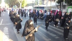 Puluhan siswa TK Persit Kartika Chandra Probolinggo mengikuti pawai dengan mengenakan jilbab dan cadar hitam, sambil membawa replika senjata, Sabtu, 18 Agustus 2018. (Courtesy Photo: istimewa).