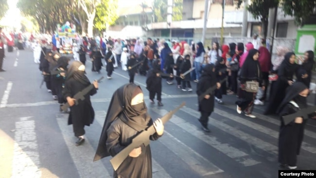 Puluhan siswa TK Persit Kartika Chandra Probolinggo mengikuti pawai dengan mengenakan jilbab dan cadar hitam, sambil membawa replika senjata, Sabtu, 18 Agustus 2018. (Courtesy Photo: istimewa).