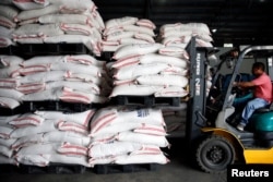 A volunteer operates a forklift to carry sacks of rice for victims of Super Typhoon Mangkhut at the Department of Social Welfare and Development, National Relief Operations Center in Pasay City, Metro Manila, in Philippines, Sept. 17, 2018.