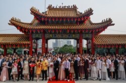 FILE - Newly-wed Malaysian couples of Chinese descent pose for photographs during a mass wedding held on the ninth day of the ninth month at the Thean Hou Temple in Kuala Lumpur on September 9, 2019. (AFP)